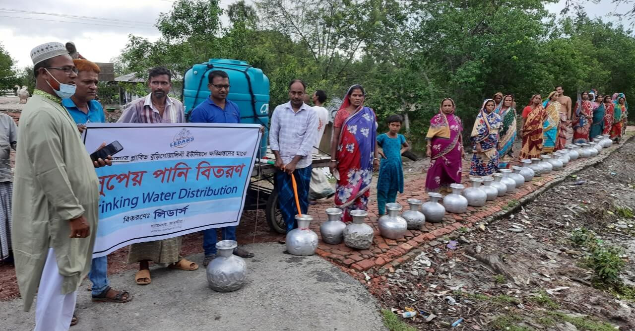 উচ্চ জোয়ারে প্লাবিত ক্ষতিগ্রস্থদের মাঝে পানি বিতরণ