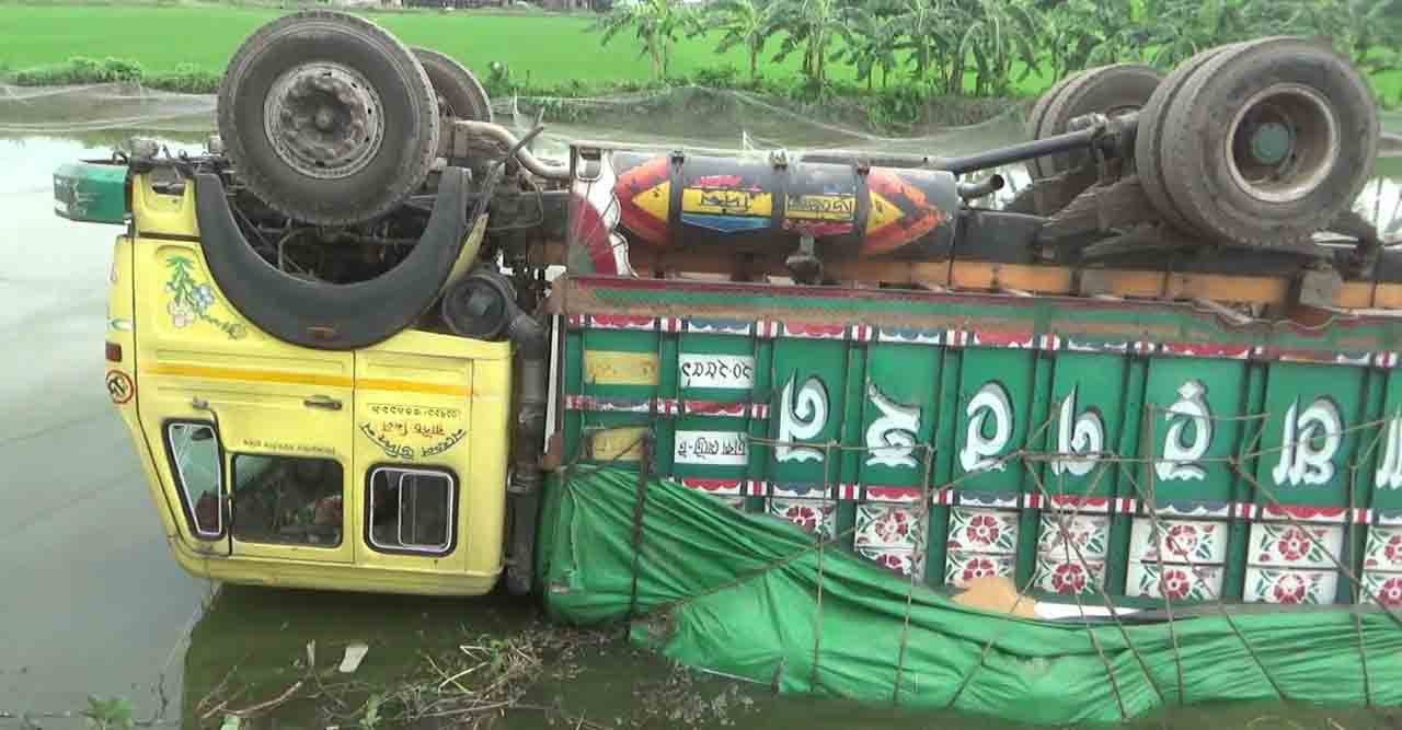 ময়মনসিংহে চিনি বোঝাই ট্রাক উল্টে পড়ে পুকুরে